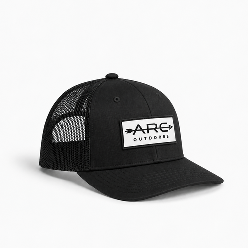 A black trucker-style cap with a white rectangular patch on the front that reads 'ARC OUTDOORS' with arrow graphics, shown on a clean white background.